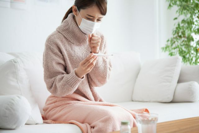 熱を測るマスク姿の女性